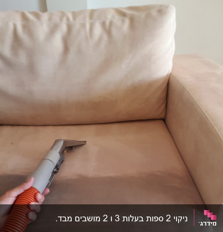 יד מחזיקה שואב אבק על ספה לניקוי